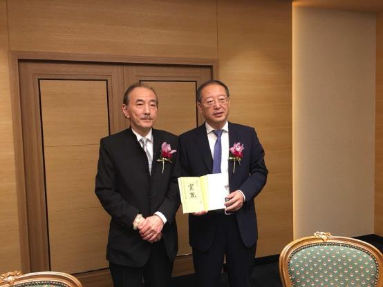 A couple of men in suits holding a book
AI-generated content may be incorrect.